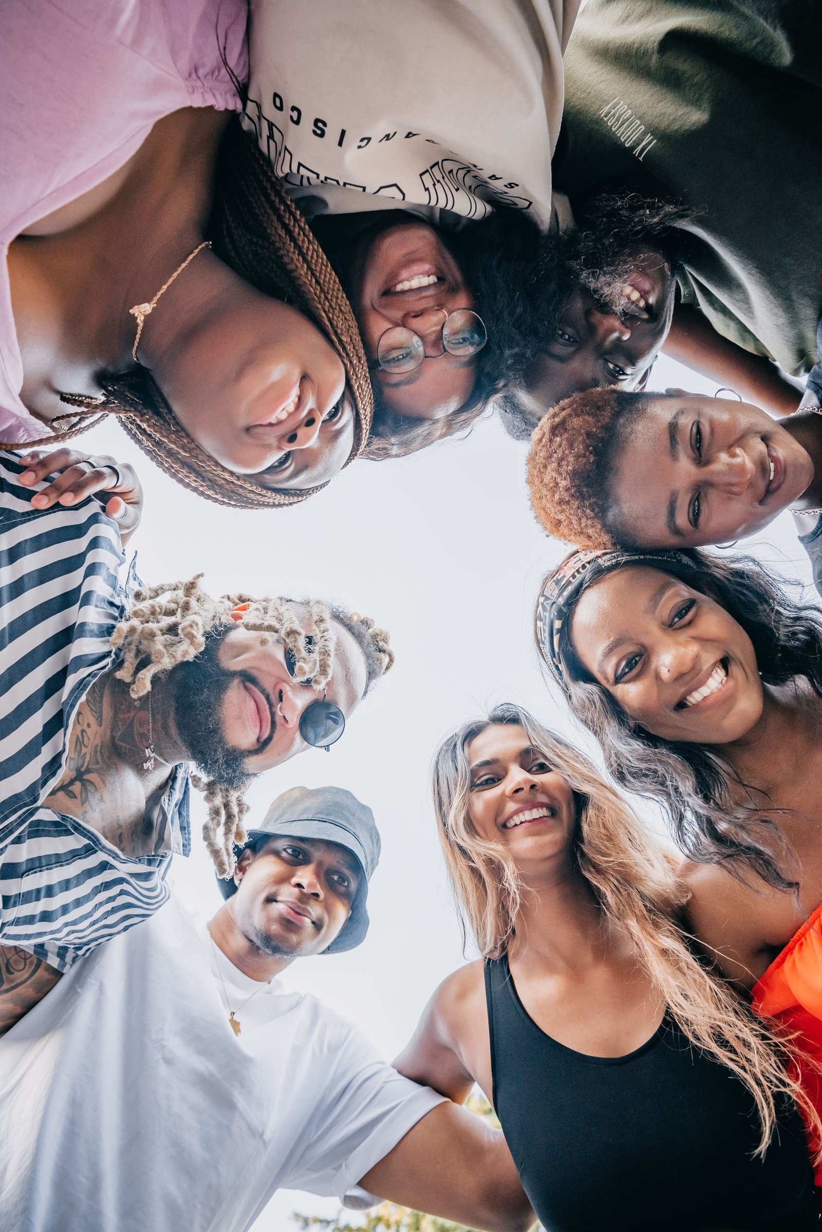 A small group of friends laughing together outdoors, resembling an informal community meetup.