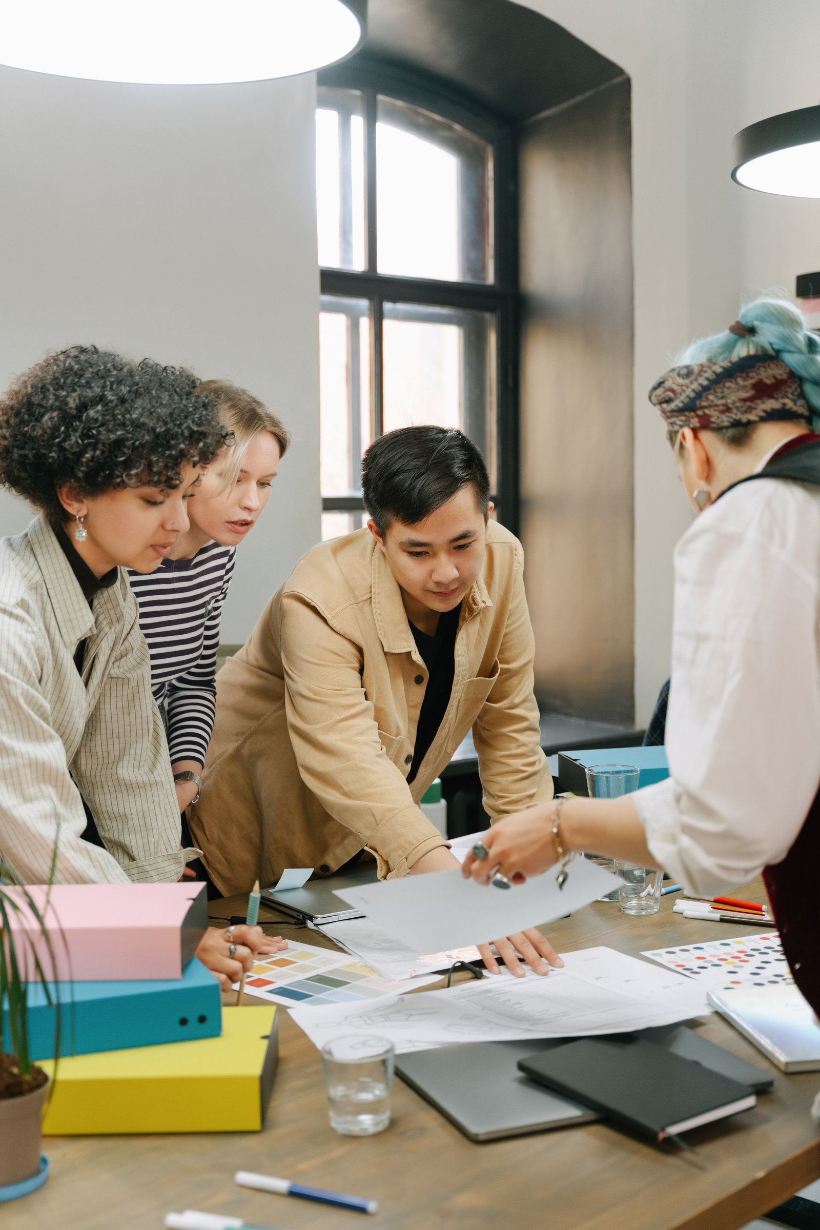 A small team gathered around a table in a meeting, discussing onboarding.